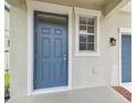 Close-up of a blue front door with a window and traditional hardware at 21284 Southern Charm Dr, Land O Lakes, FL 34637