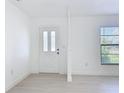 Entryway featuring a white front door with windows, bright white walls and light wood floors at 21426 Quesada Ave, Port Charlotte, FL 33952