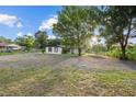 Exterior view of a one-story home with a large gravel area and green grass at 221 S Kingsway Rd, Seffner, FL 33584