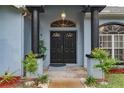 Close up of the home's front door with columns, new paint and mature landscaping at 22946 Brownwood Ct, Land O Lakes, FL 34639