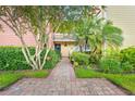 Inviting condo exterior with lush landscaping and a charming brick walkway leading to the entrance at 2424 W Tampa Bay Blvd # G204, Tampa, FL 33607