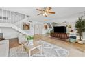 Spacious living area featuring tile flooring, staircase, a ceiling fan, and a mirrored wall at 2424 W Tampa Bay Blvd # G204, Tampa, FL 33607