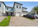 Beautiful townhome exterior featuring a brick driveway and a two-car garage at 2432 Golden Pasture Cir, Clearwater, FL 33764