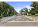 Gated community entrance with brick pavers and lush landscaping, providing privacy and security at 26 Concord Dr, Dunedin, FL 34698