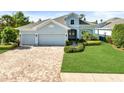 Charming single-Gathering home featuring a well-manicured lawn, 3 car garage, and lush landscaping at 26 Concord Dr, Dunedin, FL 34698