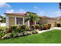 Charming single-story home with a front yard palm tree, lush landscaping, and a well-maintained lawn at 2728 Abbey Grove Dr, Valrico, FL 33594