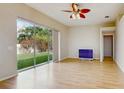 Bright living room with wood floors, ceiling fan, and sliding glass doors to the outdoor space at 2728 Abbey Grove Dr, Valrico, FL 33594