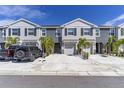 Charming two-story townhome featuring a two-car driveway, one car garage, and tropical landscaping at 2801 Midnight Pearl Dr, Sarasota, FL 34240