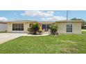 Inviting single-story home featuring lush landscaping, a driveway, and a charming courtyard, perfect for outdoor relaxation at 3401 Pinon Dr, Holiday, FL 34691