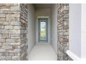 Inviting entrance with stone pillars and a beautifully designed front door at 3448 Yellow Leaf Cir, Spring Hill, FL 34609