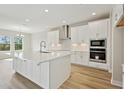 Bright, modern kitchen with white cabinets, stainless steel appliances, and a large center island at 3448 Yellow Leaf Cir, Spring Hill, FL 34609