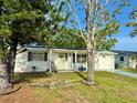 View of white house with trees in front and solar panels on the roof at 3542 Monticello St, New Port Richey, FL 34652