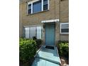 Inviting condo entrance with a teal door, awning, and well-manicured landscaping at 5247 81St N St # 2, St Petersburg, FL 33709