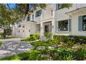 Stunning home featuring lush landscaping, a paver driveway, an attached two-car garage, and a charming front entrance at 534 Ladrone Ave, Tampa, FL 33606