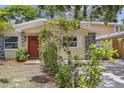 View of the front exterior with a red front door, gray stone accents, and landscaping at 5611 Burlington N Ave, St Petersburg, FL 33710