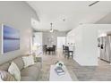 Open-concept living room featuring stylish furnishings, neutral paint and flooring, and adjacent dining and kitchen areas at 7630 Sailwinds Pass, Port Richey, FL 34668