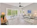 Bright living room showcasing sliding glass doors to a porch, neutral walls and flooring, and modern decor at 7630 Sailwinds Pass, Port Richey, FL 34668