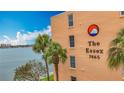 Exterior of The Essex building with palm trees and partial water view at 7665 Sun Island Dr # 206, South Pasadena, FL 33707