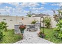 Picturesque backyard featuring a cozy fire pit area with stone accents and lush landscaping at 8310 Hardy Bay Loop, Wesley Chapel, FL 33545