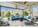 Inviting screened-in patio with comfortable seating, ceiling fans, and a view of the landscaped backyard at 8310 Hardy Bay Loop, Wesley Chapel, FL 33545