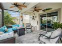 Relaxing covered patio with stylish furniture, ceiling fans, and a seamless transition to the backyard at 8310 Hardy Bay Loop, Wesley Chapel, FL 33545