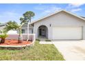 Inviting home showcasing a well-maintained lawn, stone-accented flower bed, and attached two-car garage at 8499 101St Ave, Seminole, FL 33777