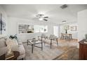 Bright living room featuring wood floors, neutral furniture, ceiling fan, and open layout to dining area at 8499 101St Ave, Seminole, FL 33777