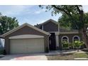 Charming home featuring a two-car garage, arched windows, and meticulous landscaping at 904 Grand Canyon Dr, Valrico, FL 33594