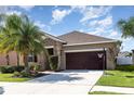 Beautiful home with palm trees, manicured lawn, and a two-car garage at 11711 Winterset Cove Dr, Riverview, FL 33579