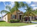 Charming single-Gathering home with lush landscaping, mature palm trees, and a two-car garage at 11711 Winterset Cove Dr, Riverview, FL 33579
