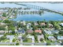 Stunning aerial view of waterfront homes, featuring lush landscaping and bridge views at 120 Crestwood Ln, Largo, FL 33770