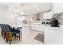 Modern kitchen featuring sleek countertops, pendant lighting, a breakfast bar, and stainless steel appliances at 120 Crestwood Ln, Largo, FL 33770
