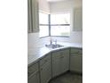Modern kitchen featuring sleek countertops, stainless steel sink, and classic white subway tile backsplash at 1200 Tarpon Woods Blvd # M6, Palm Harbor, FL 34685