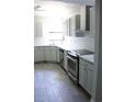 Bright kitchen boasts stainless appliances, subway tile, shaker cabinets, and wood-look tile flooring at 1200 Tarpon Woods Blvd # M6, Palm Harbor, FL 34685