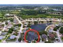 Overhead shot of a suburban home with a screened pool, lush surroundings, and a peaceful pond nearby at 1218 Willow Bend Way, Lutz, FL 33549