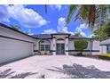 Inviting home with double door entrance, a well-maintained lawn, and a spacious driveway leading to a two-car garage at 1218 Willow Bend Way, Lutz, FL 33549