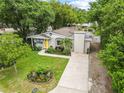 An aerial view of a cozy home boasting lush landscaping, complemented by a long driveway at 1226 E Henry Ave, Tampa, FL 33604
