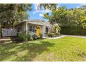 A cozy home featuring a welcoming yellow door framed by vibrant green landscaping at 1226 E Henry Ave, Tampa, FL 33604