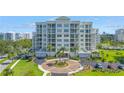 Luxury condominium showcasing lush landscaping, circular driveway, and coastal architecture, embodying upscale community living at 125 Belleview Boulevard # 203, Belleair, FL 33756