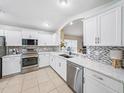 Well-lit kitchen featuring stainless steel appliances, mosaic tile backsplash, and light granite countertops at 1338 Winding Willow Dr, Trinity, FL 34655