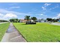 View of a well-manicured front lawn and sidewalk leading to a charming single-story home with a red tile roof at 1414 75Th Nw St, Bradenton, FL 34209