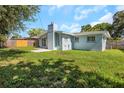 Rear exterior of the house featuring well-maintained landscaping, a chimney, and an open yard at 1420 Temple St, Clearwater, FL 33756