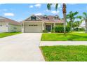 Charming home with a manicured lawn and a mature palm tree, creating a welcoming curb appeal at 17342 Lawn Orchid Loop, Land O Lakes, FL 34638