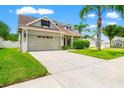 Lovely home featuring an attached two-car garage and meticulous landscaping, showcasing great curb appeal at 17342 Lawn Orchid Loop, Land O Lakes, FL 34638