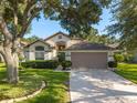 Charming single-Gathering home with a well-maintained lawn, mature trees, and a two-car garage at 2043 Wrangler Dr, Brandon, FL 33511