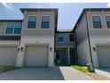 Charming townhome featuring a two-car garage, neutral color scheme, and well-maintained landscaping and brick paved driveway at 2487 Golden Pasture Cir, Clearwater, FL 33764