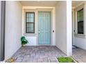 Inviting front entrance with a light blue door, stylish stonework, and a window providing natural light at 2487 Golden Pasture Cir, Clearwater, FL 33764