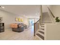 Open-concept living room with tile flooring, a plush couch, and stairs leading to the upper level at 2487 Golden Pasture Cir, Clearwater, FL 33764