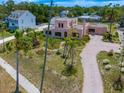 Exterior view of home, including lush landscaping, unique design, and patterned driveway at 43 Edgewater Dr, Dunedin, FL 34698