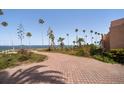 Driveway view of the home surrounded by mature palms and with waterfront views at 43 Edgewater Dr, Dunedin, FL 34698